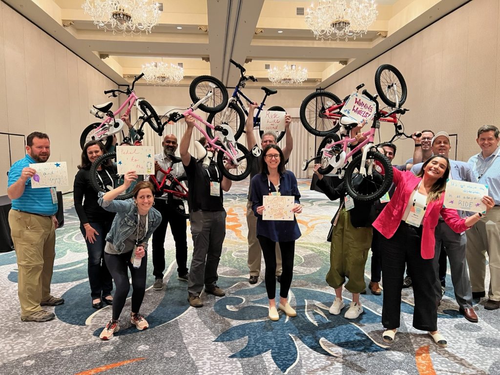 A charity group posing with their bicycles during a Bike Build event.