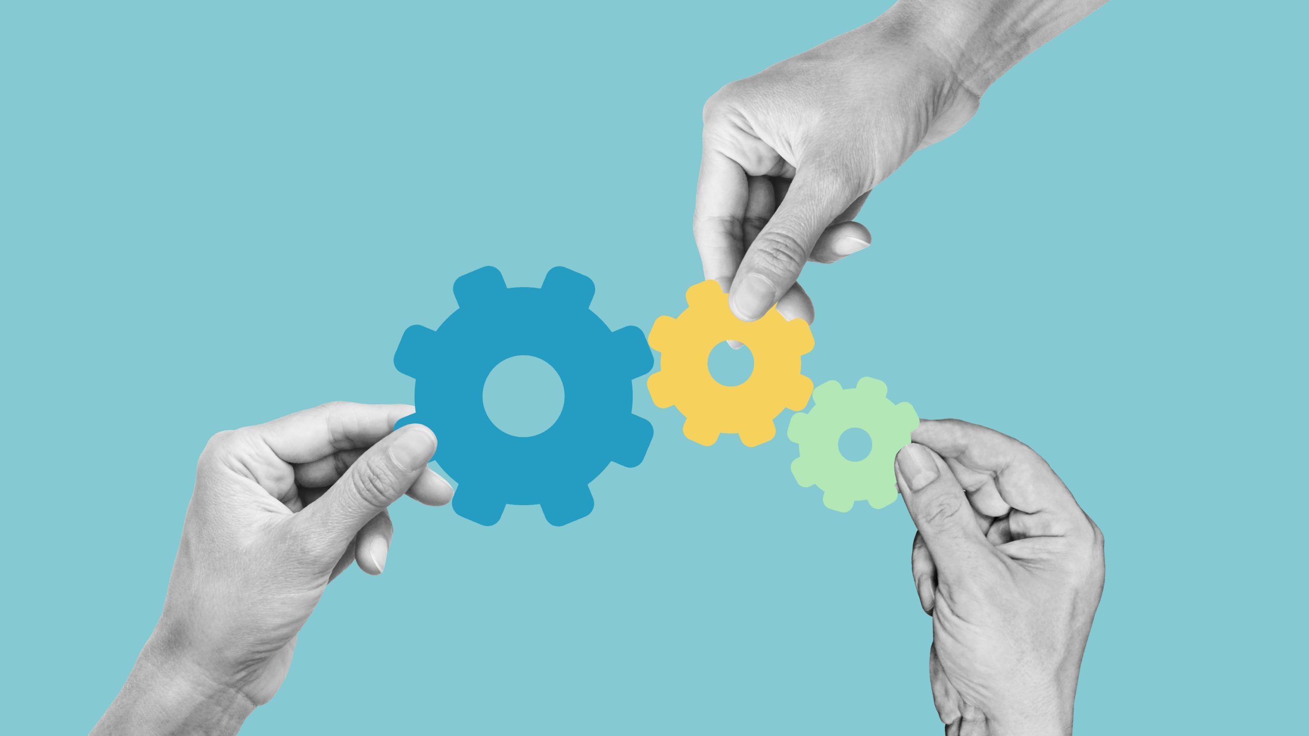 Three hands hold interlocking blue, yellow, and green gears against a light blue background, symbolizing teamwork and collaboration—ideal for illustrating effective team-building activities.